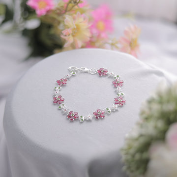 A Ruby Floral Bracelet with intricate silver detailing and deep red stones.