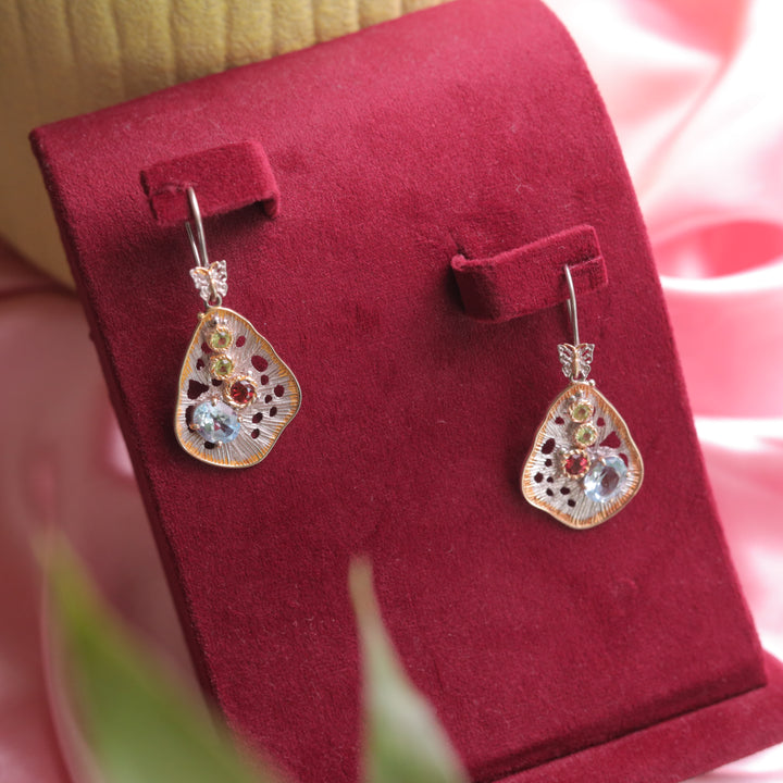 A close-up of Kaizi Peridot Garnet Topaz Earrings, showcasing their vibrant mix of gemstones.