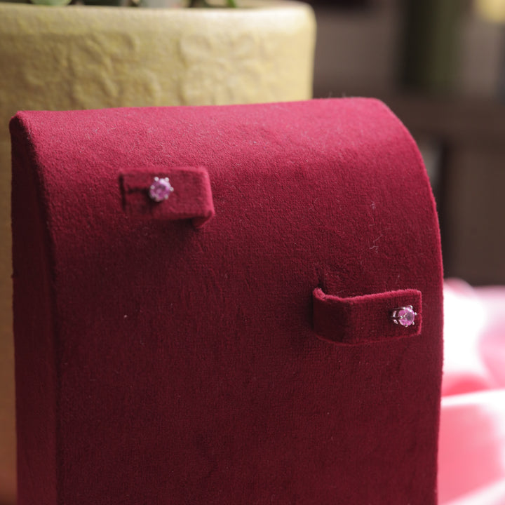 A close-up of Dark Pink Stud Earrings, glowing with sophistication.