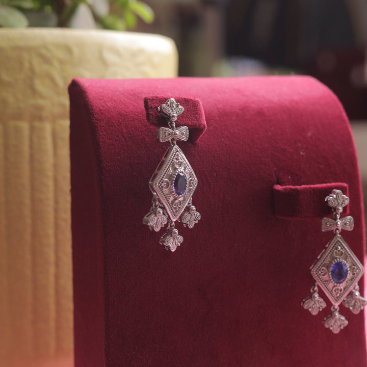 A close-up of Oxidized Blue Diamond Shape Earrings, showcasing intricate silverwork.