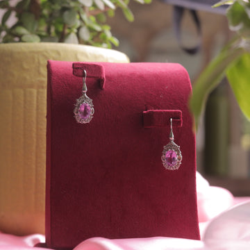 A pair of Kaizi Earrings (Pink), featuring a delicate pink gemstone.