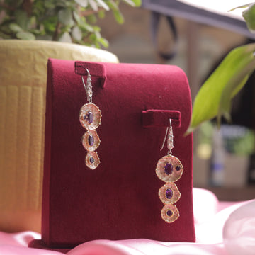 A pair of Kaizi Amethyst Earrings featuring a deep purple amethyst gemstone.